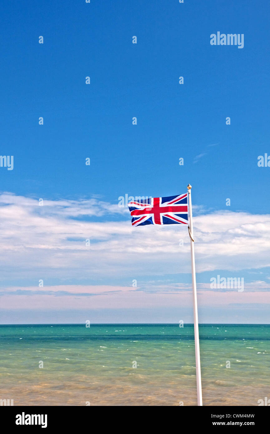 Union flag flying against summer blue sky and sea Stock Photo