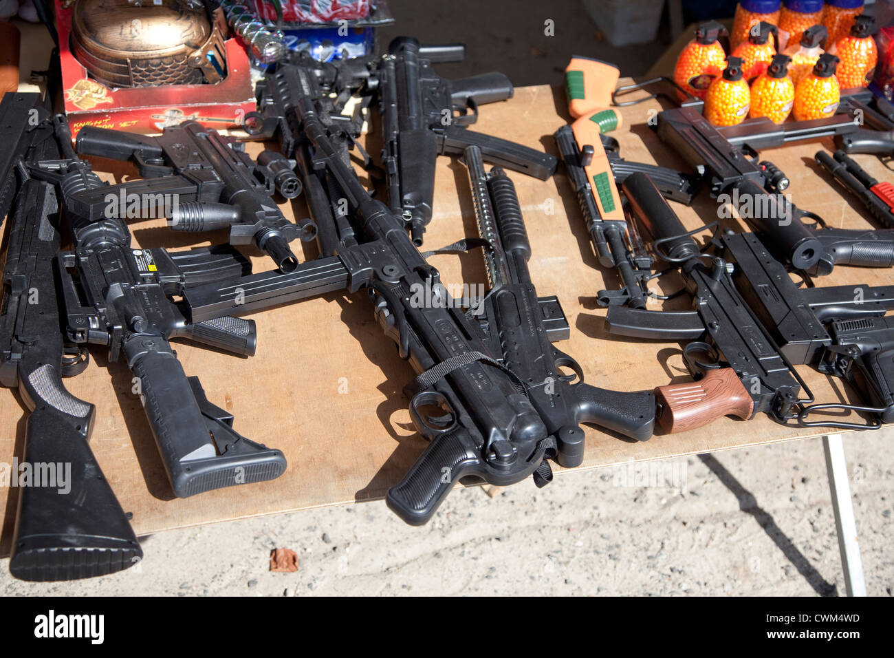 Replica assault rifles, guns and grenades for sale at sidewalk flea market. Rzeczyca Central Poland Stock Photo