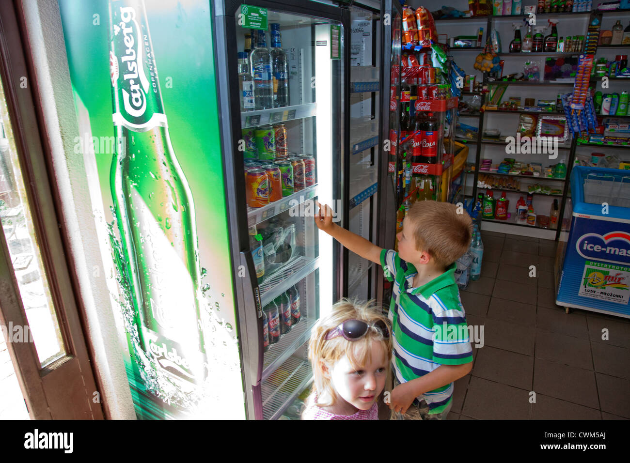 Children inspecting soda selection in small Polish grocery connivence store. Krolowa Wola Central Poland Stock Photo