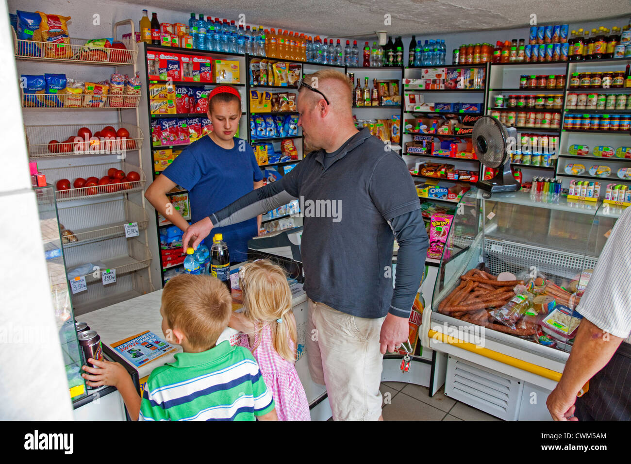 Purchasing water, cola and snacks at a small Polish convenience grocery store sklep. Krolowa Wola Central Poland Stock Photo