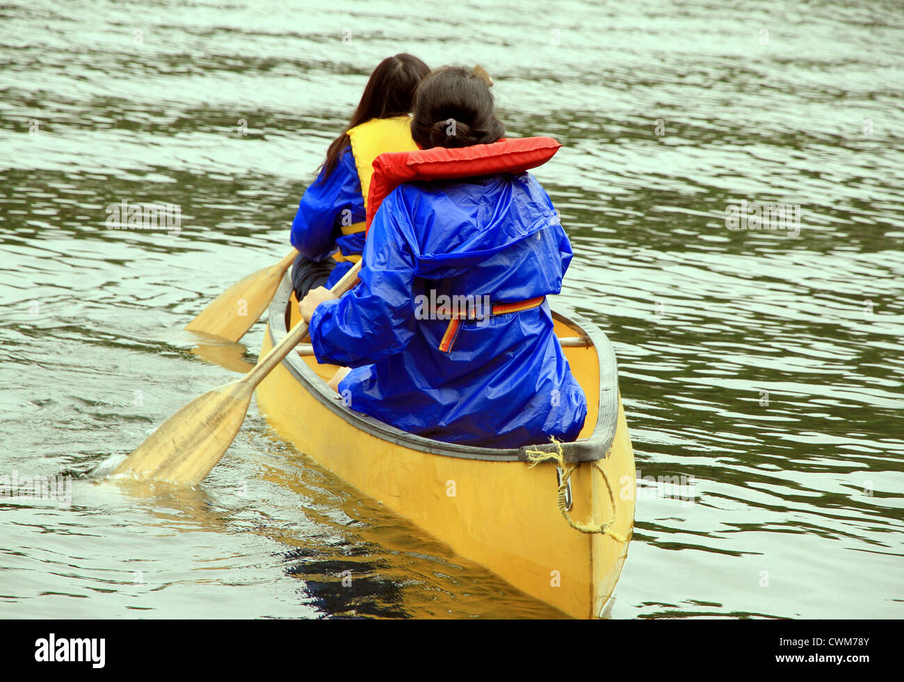 Two women paddling on a canoe Stock Photo - Alamy