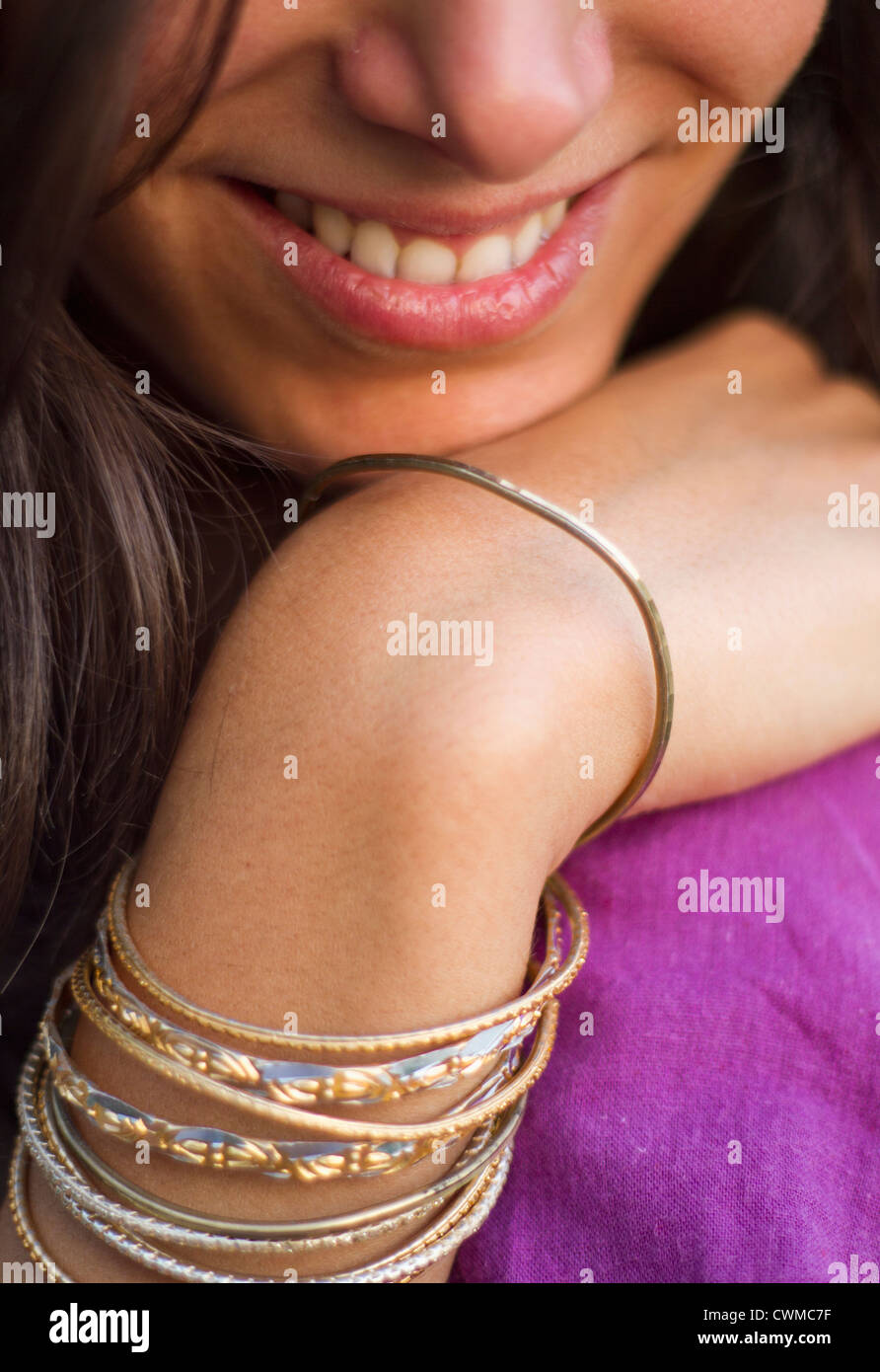 India, Young woman wearing Indian bangles,smiling, close up Stock Photo