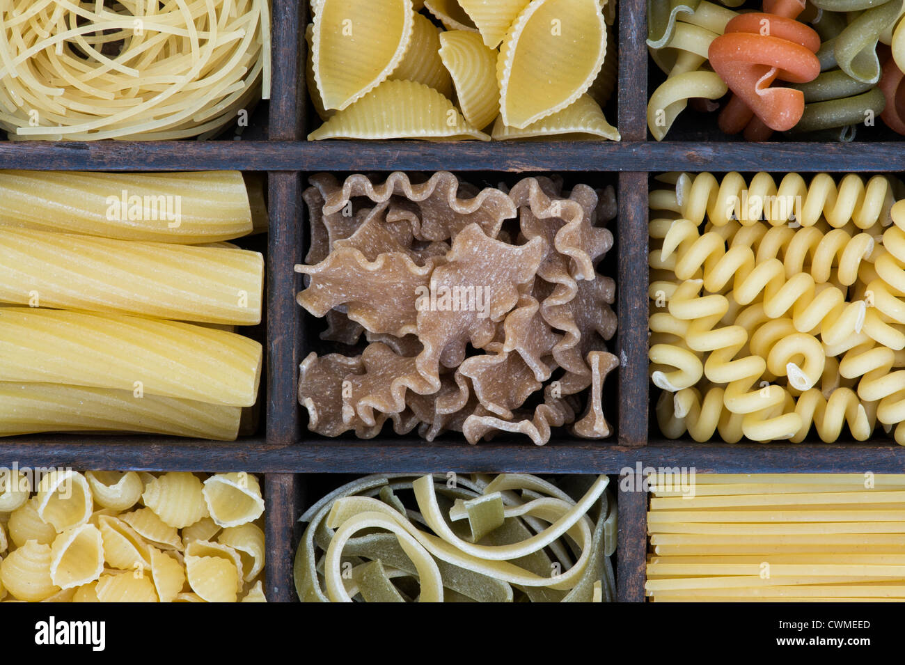 Different types of dried pasta in a wooden tray Stock Photo