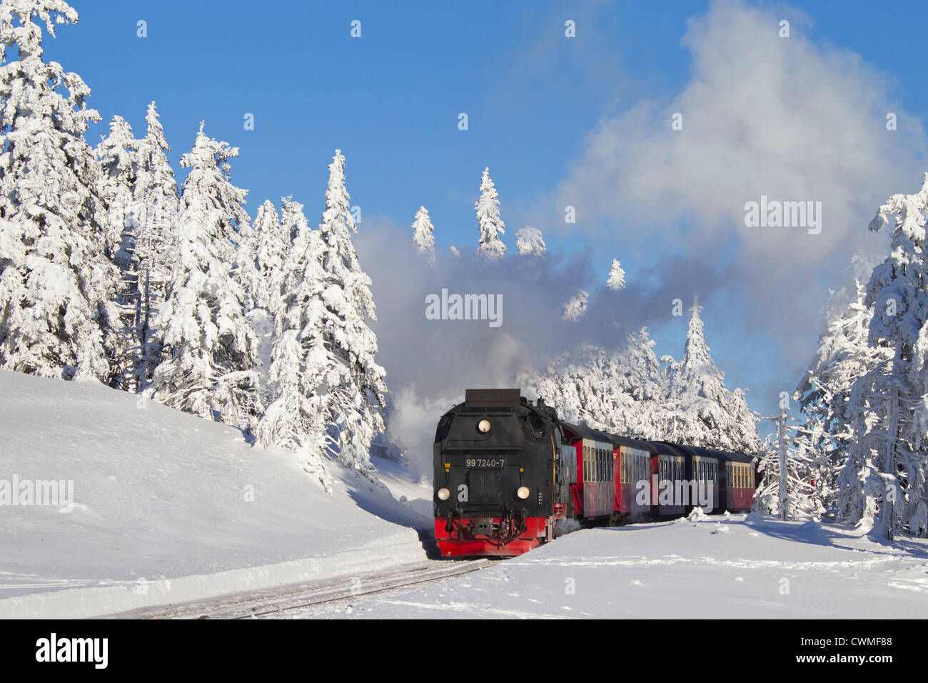 Steam train riding the Brocken Narrow Gauge railway line in the snow in winter at the Harz National park, Saxony-Anhalt, Germany Stock Photo