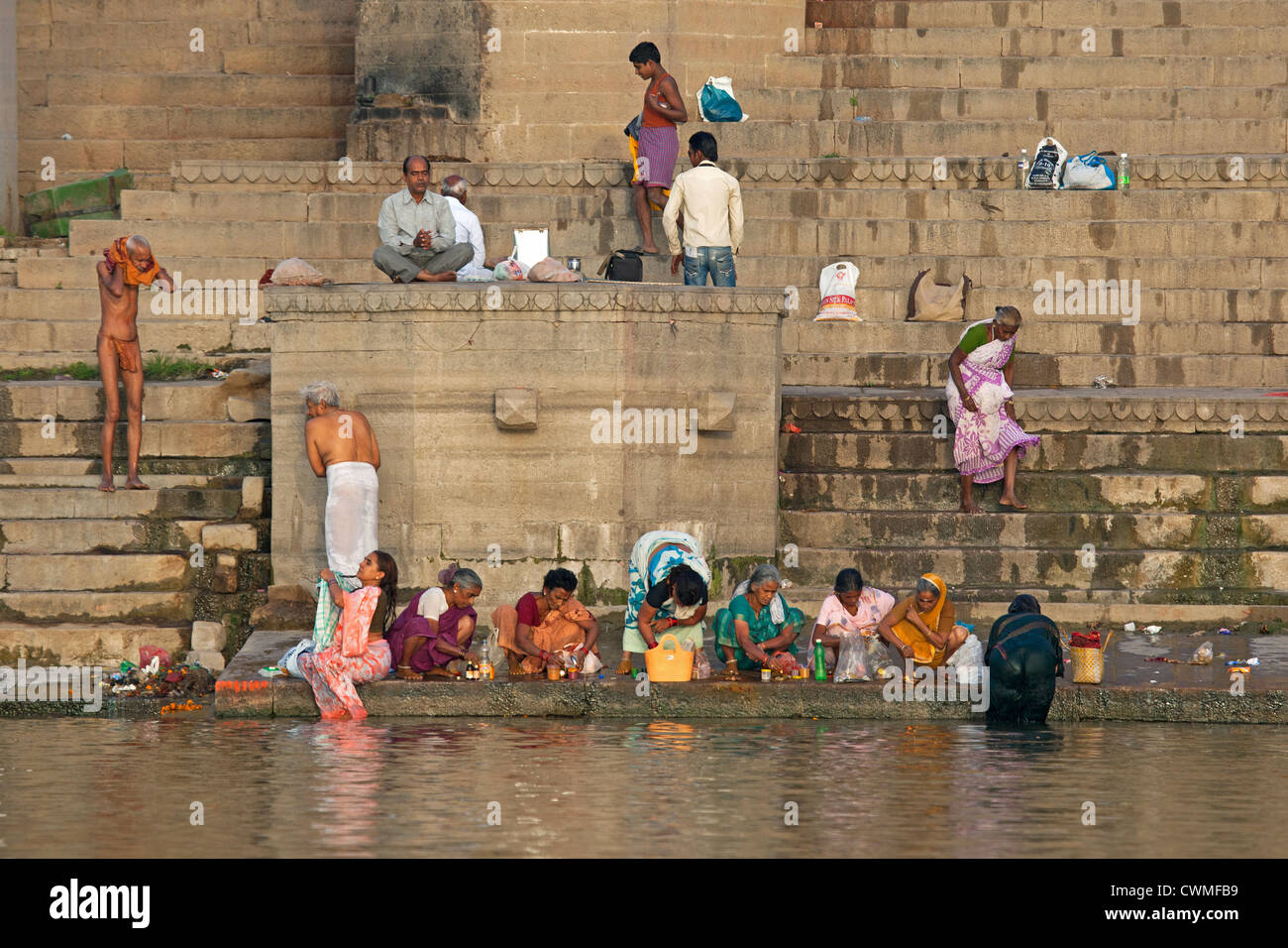 Indian pilgrims bathing and praying in the Ganges river at a ghat at Varanasi, Uttar Pradesh, India Stock Photo