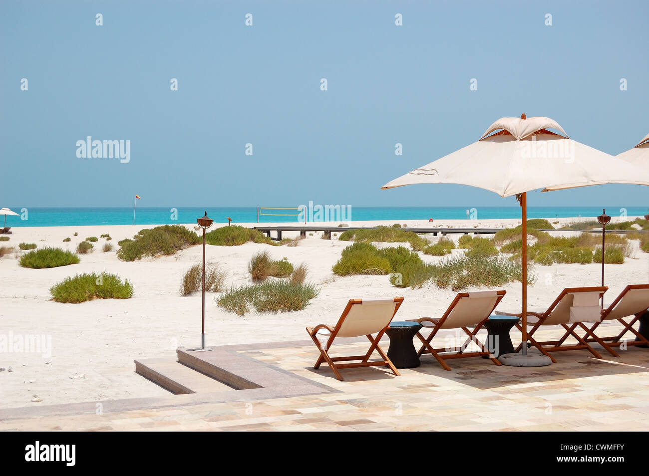 Sunbeds and umbrellas at the beach of luxury hotel, Abu Dhabi, UAE Stock Photo