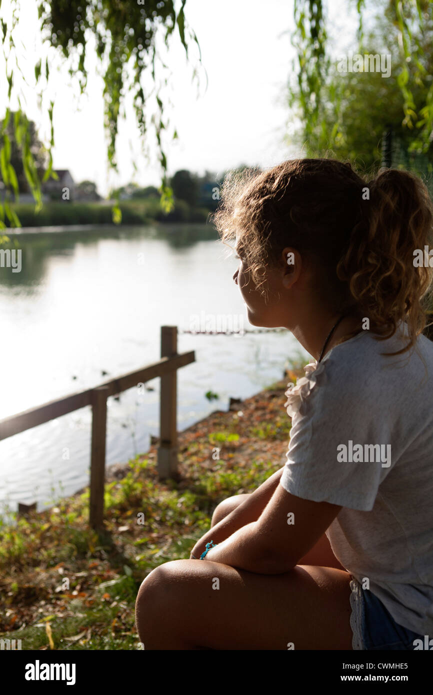 Young dreamy girl looking at the river - profile Stock Photo