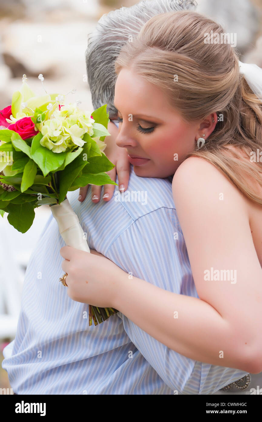 Bride getting a hug from a congratulator right after wedding ceremony. Stock Photo