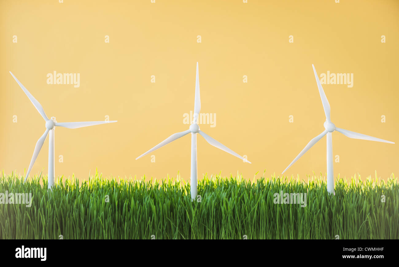 Model wind turbines in grass on yellow background Stock Photo - Alamy