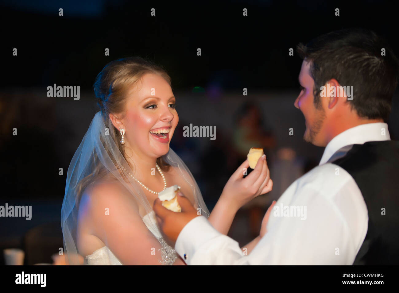 Bride And Groom Smearing Each Others Faces With Icing During A