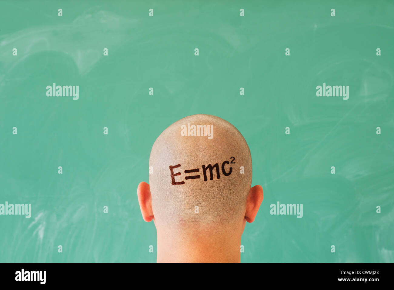 Man with formula on head in front of blackboard Stock Photo