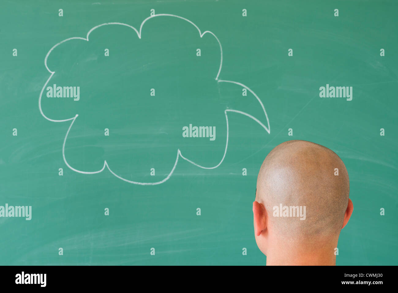 Man in front of blackboard with drawing depicting speech bubble Stock Photo