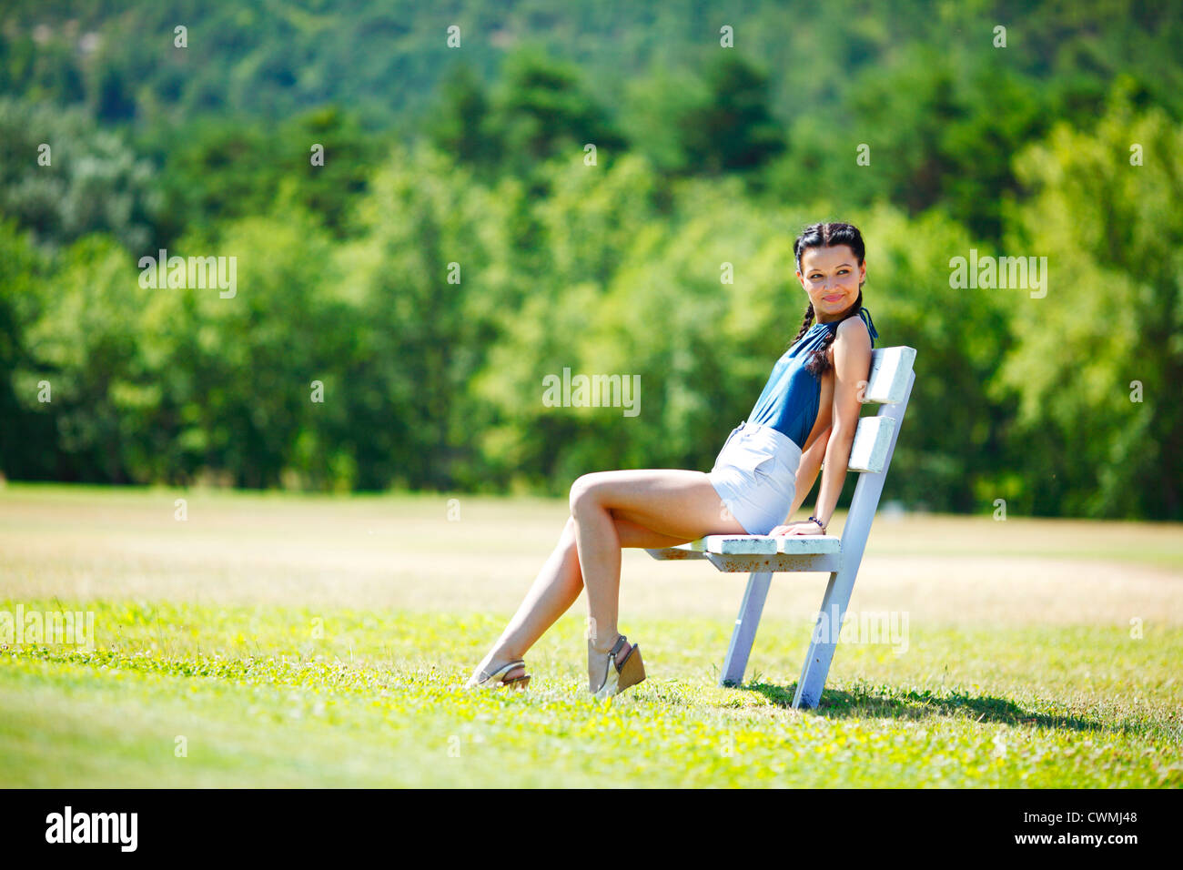 Young woman sitting on the bench in park Stock Photo - Alamy
