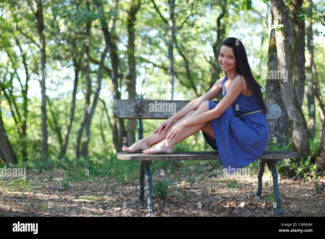 Young woman sitting on the bench in park Stock Photo - Alamy
