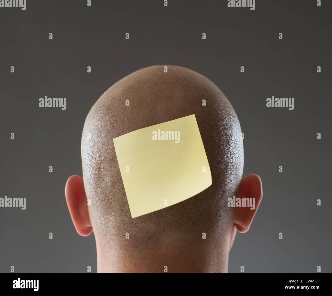 Back view of man with adhesive note on shaved head Stock Photo