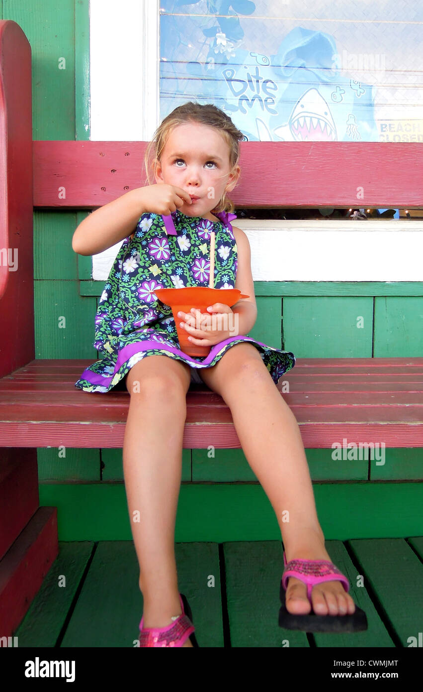 Young girl eating shaved ice in Halewia, Oahu, Hawaii. Stock Photo