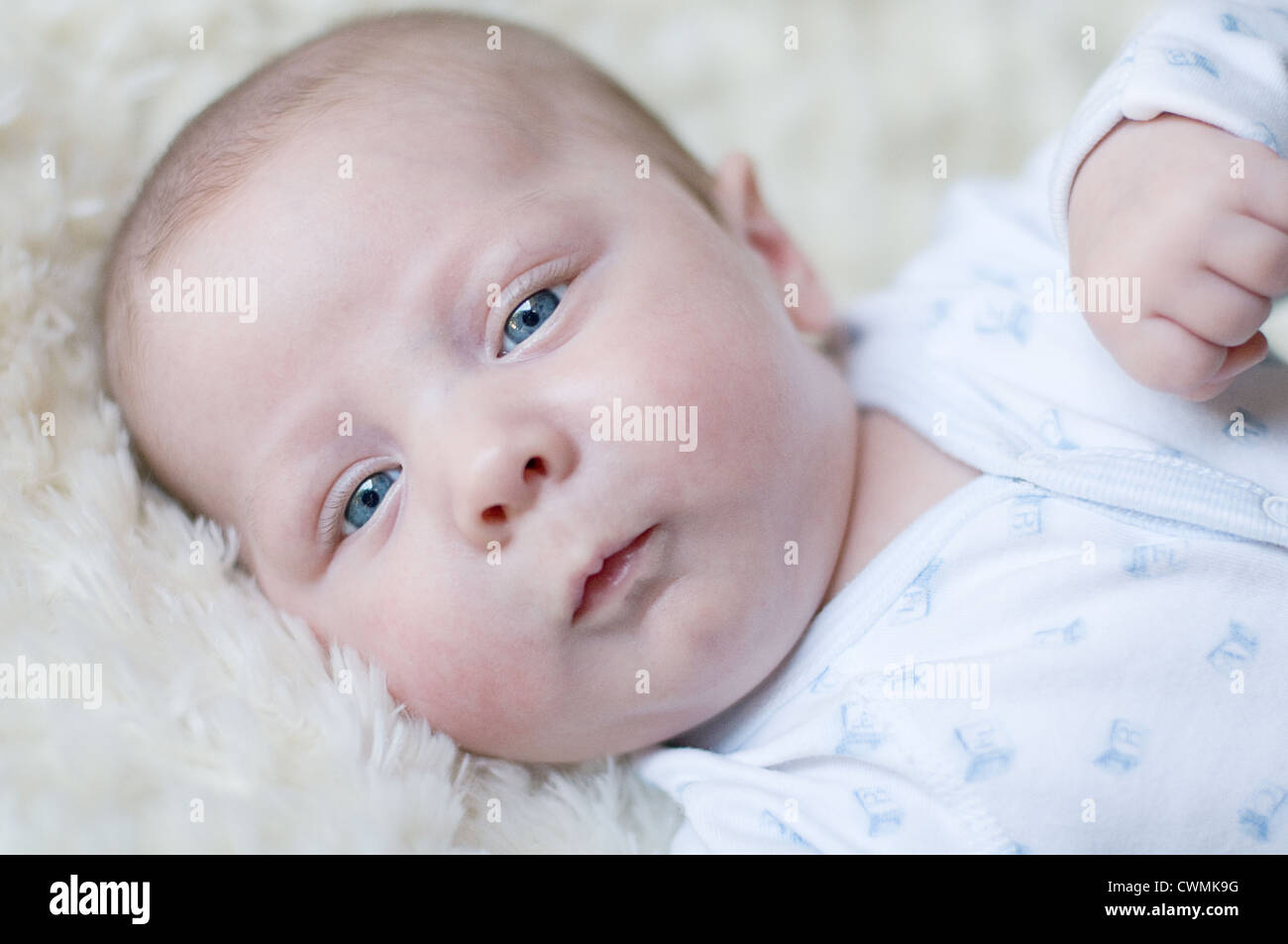 3 months old boy laying down and looking at camera Stock Photo