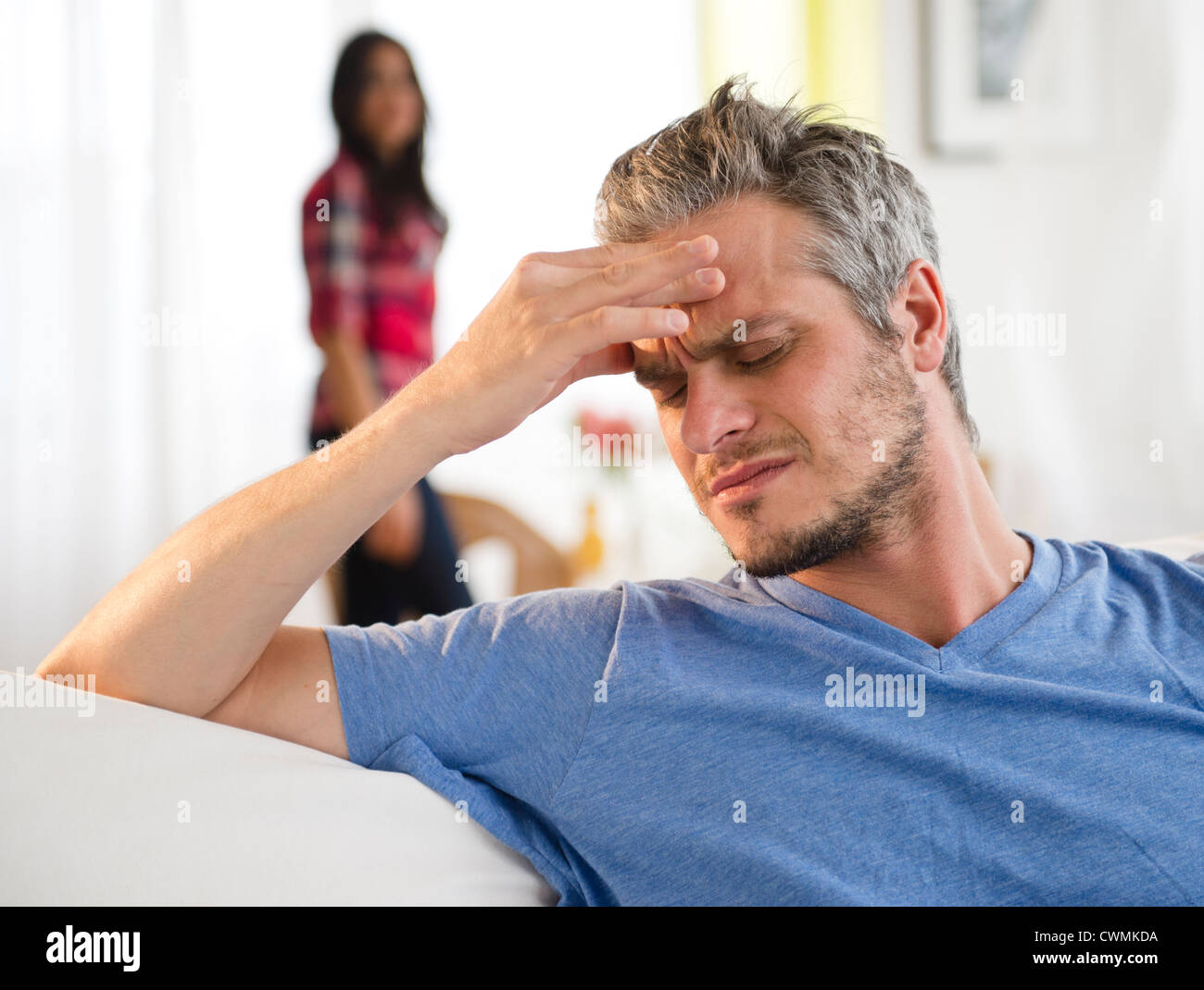 USA, New Jersey, Jersey City, Man touching forehead, woman in background Stock Photo