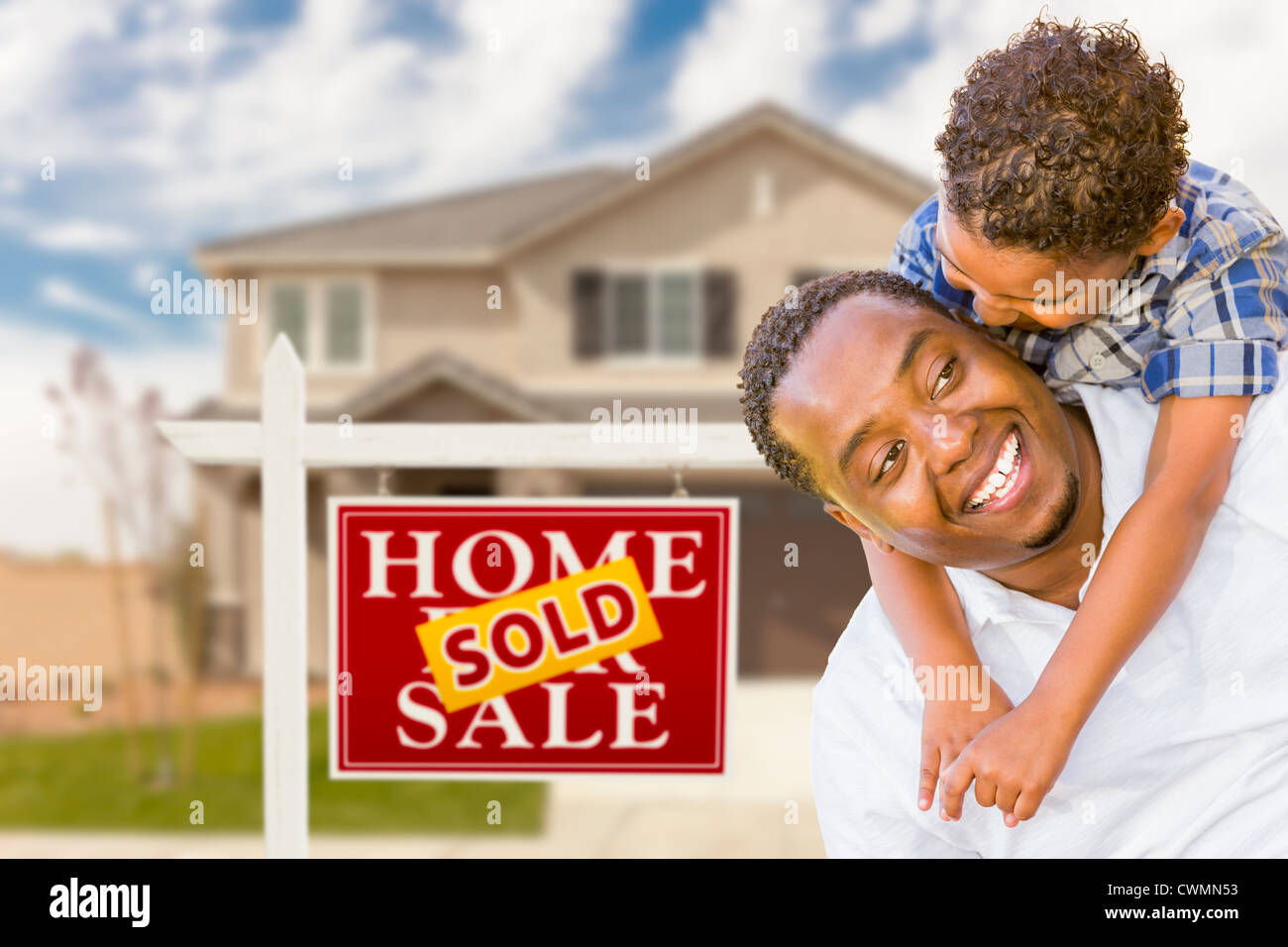 Happy Mixed Race Father and Son In Front of Sold Real Estate Sign and ...