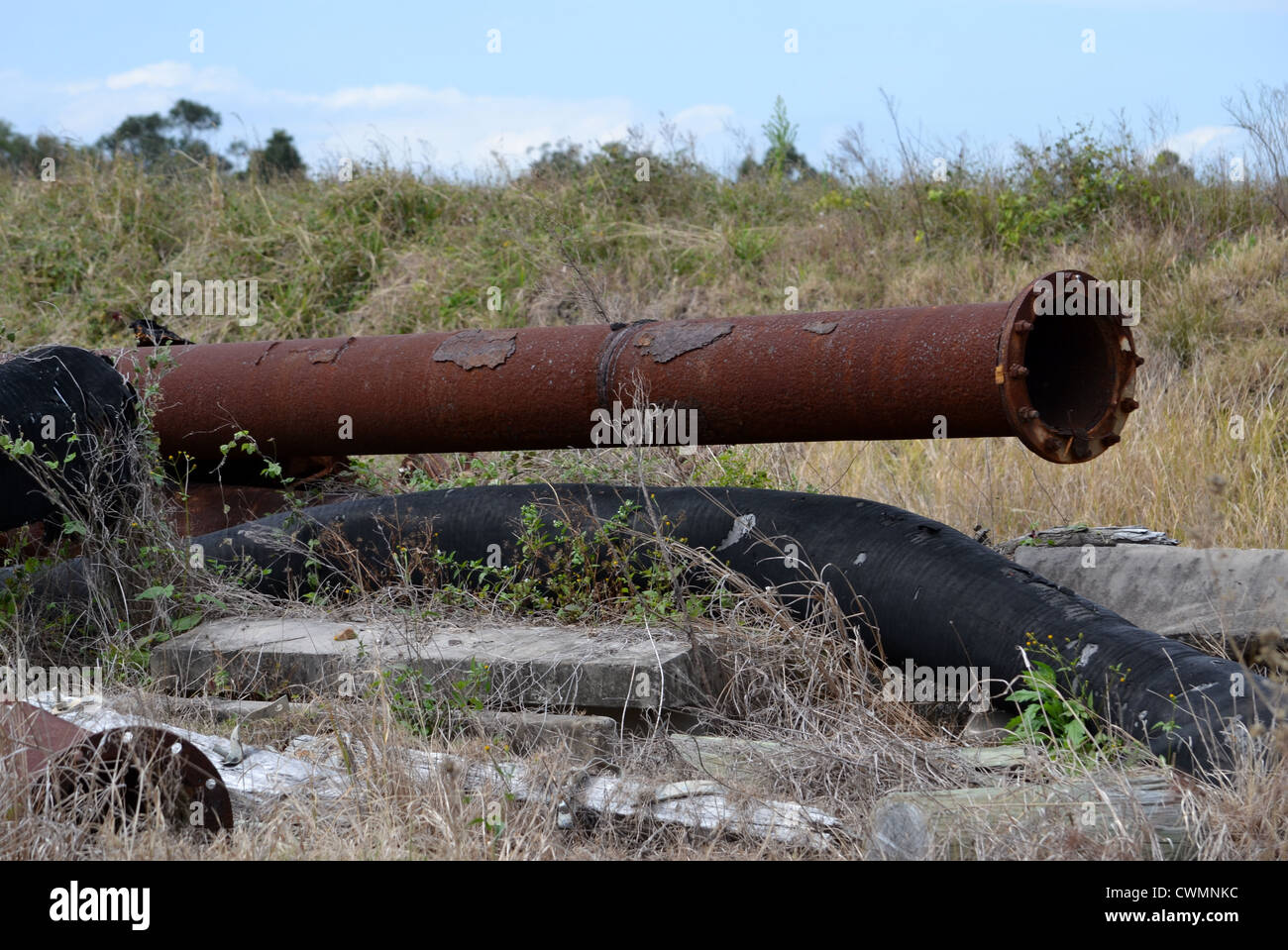 Pile of of broken telephone poles and rusty pipes at construction site Stock Photo