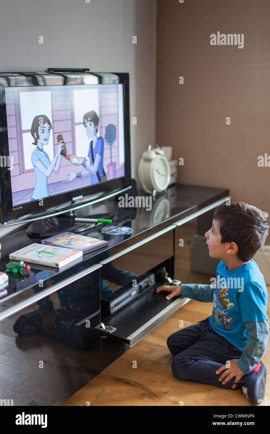 Boy 4 years old watches cartoons on television Stock Photo