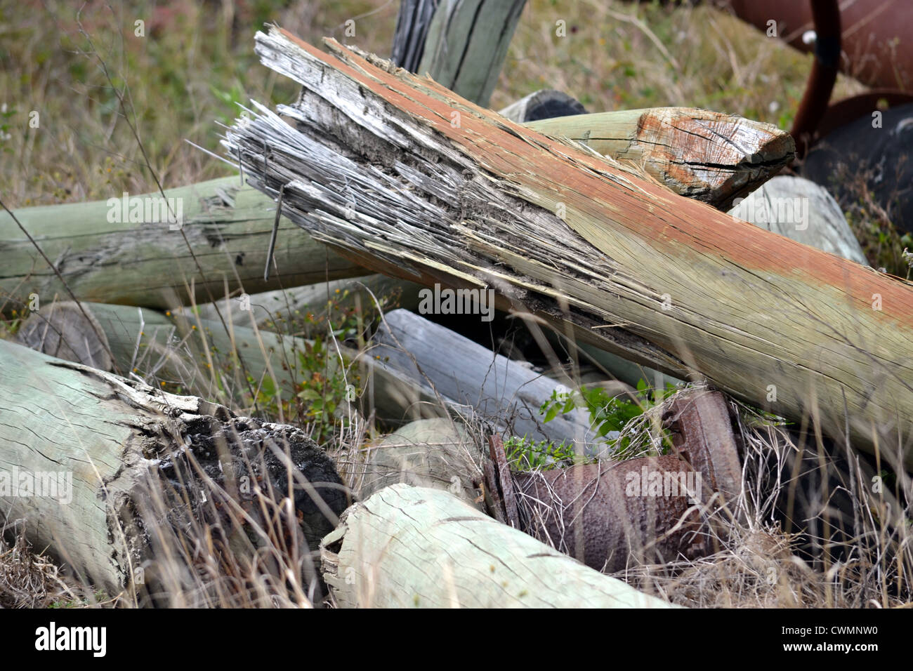 Pile of of broken telephone poles and rusty pipes at construction site Stock Photo