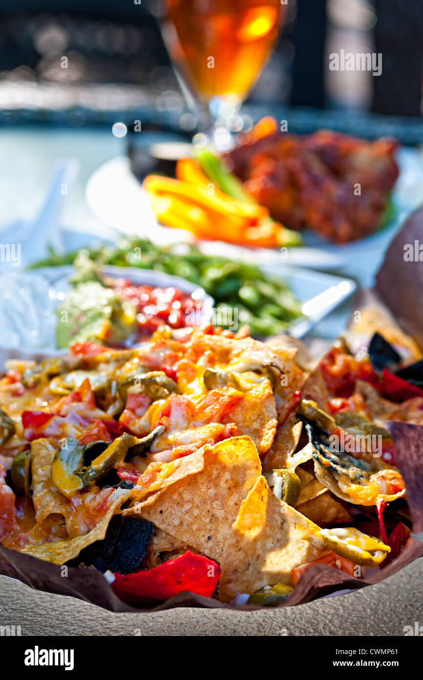 Basket of nachos and other appetizers on restaurant table Stock Photo