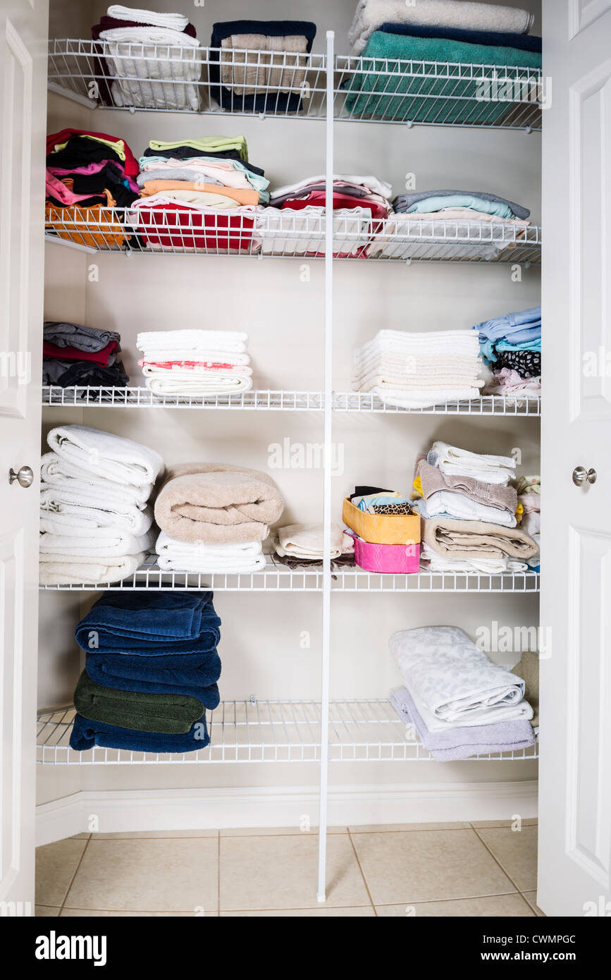 clean and organized bathroom closet with towels on shelves Stock Photo