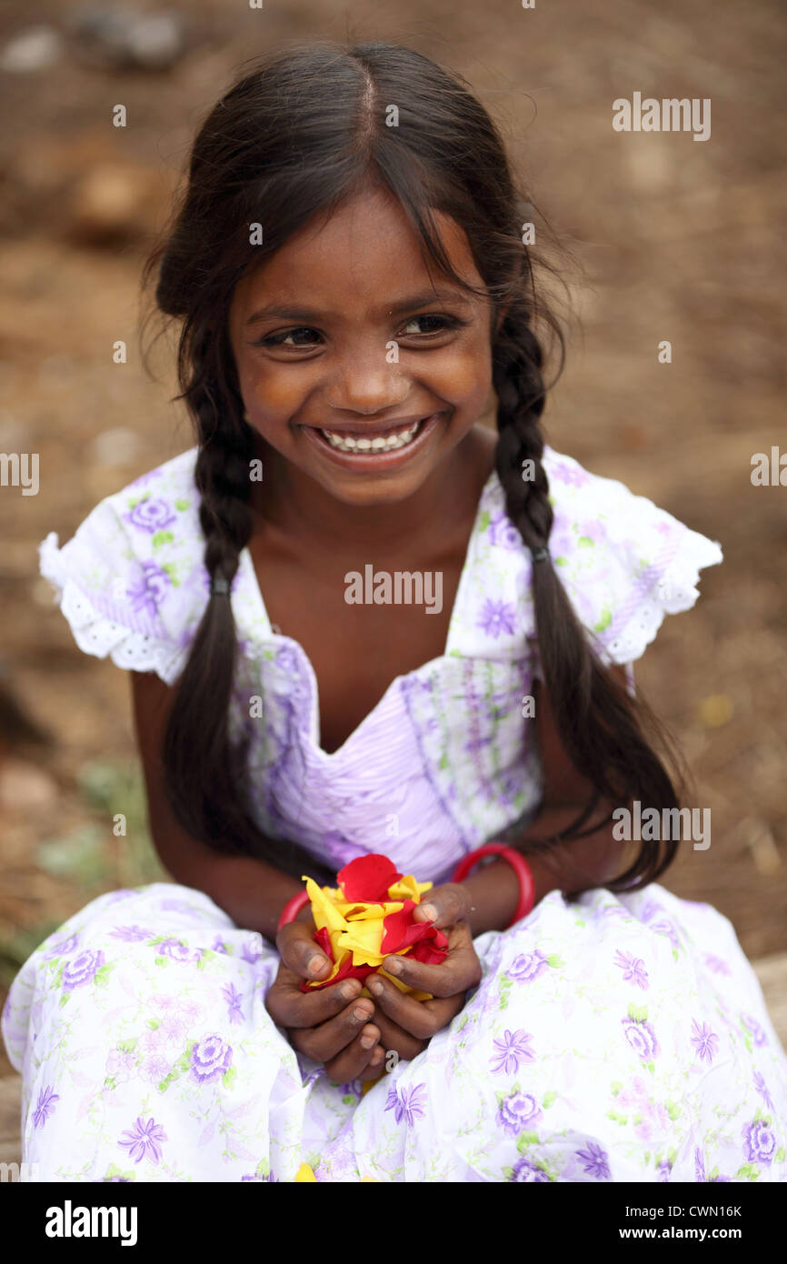 Young Indian rural girl holding rose petals Andhra Pradesh South India
