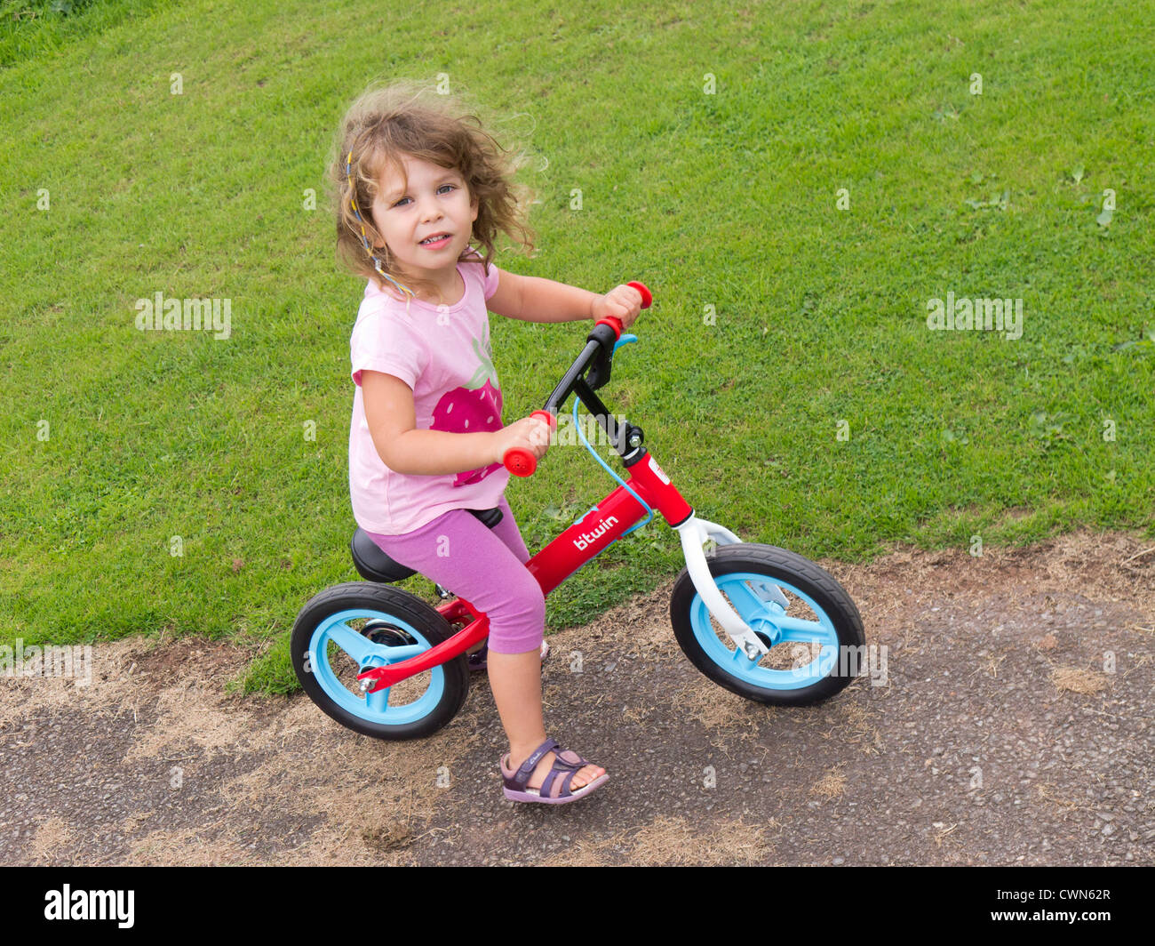 Young child using a balance bike to learn to ride a bicycle Stock Photo Alamy