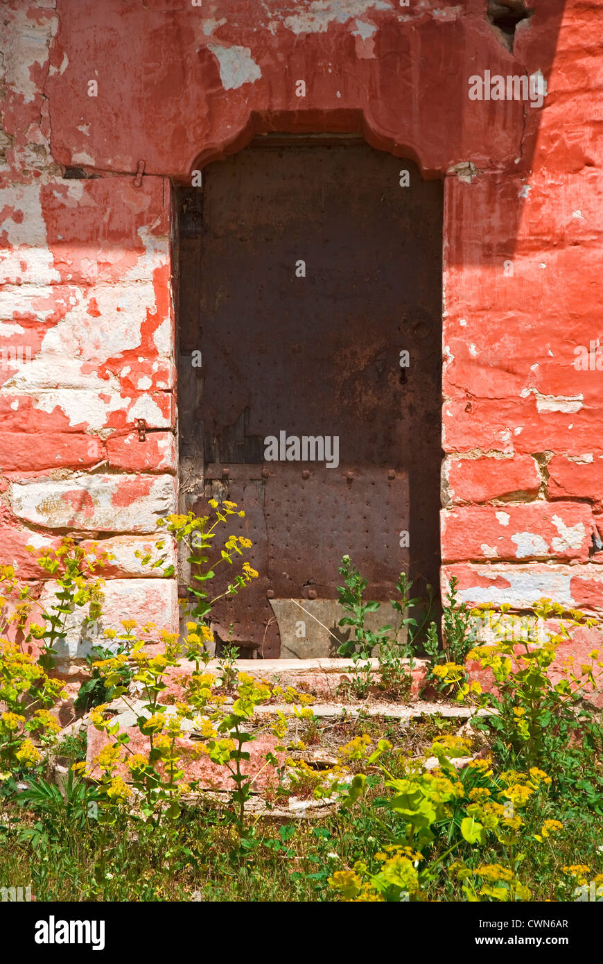 Colorful facade of an old stone house with weathered metal door on ...