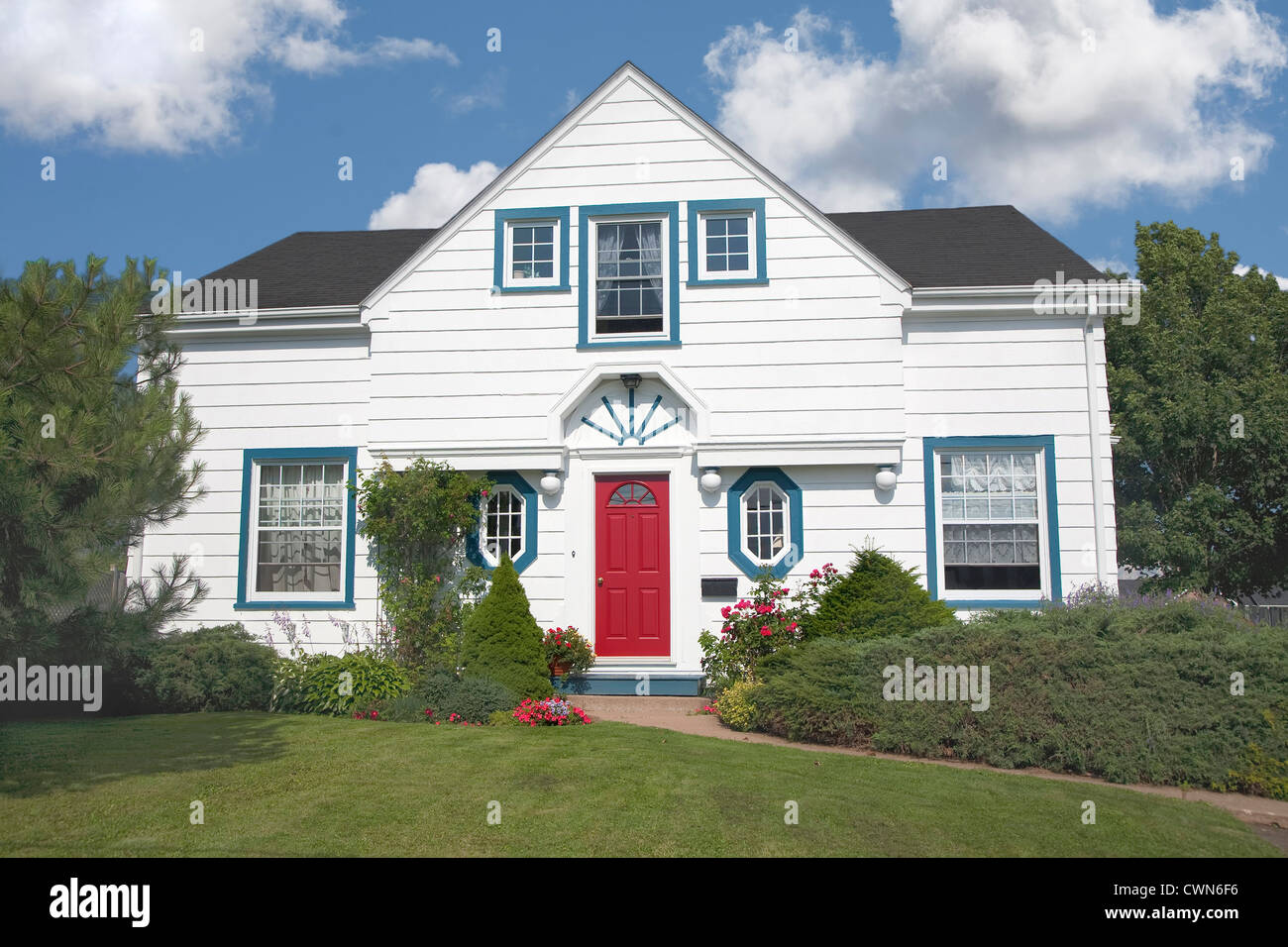 Older style traditional two story home with colorful flowers. Stock Photo