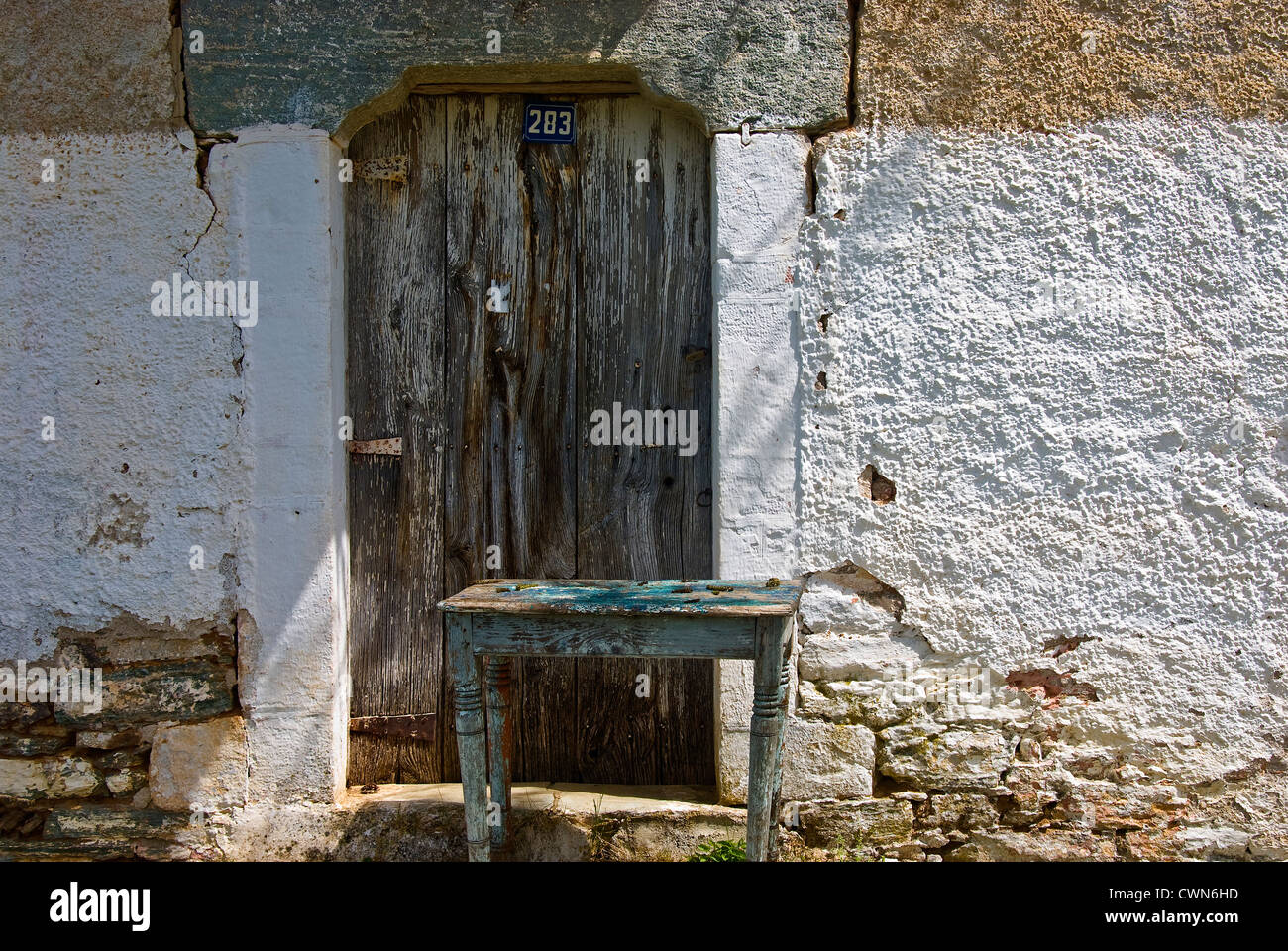 Facade of an old stone cottage with weathered wooden door on Pelion Peninsular, Thessaly, Greece Stock Photo