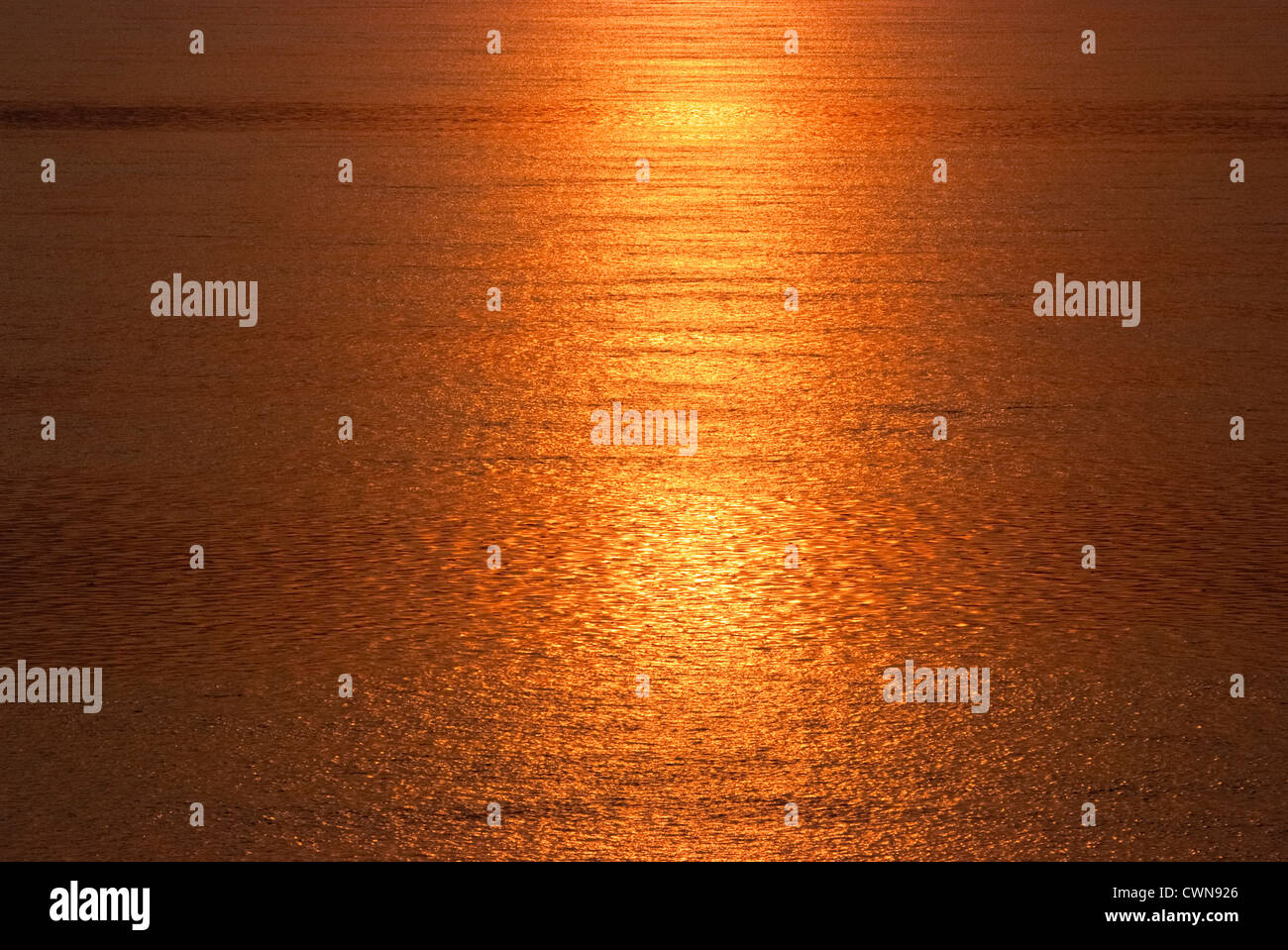 Sea water turns into golden by the reflection of sunset Stock Photo - Alamy