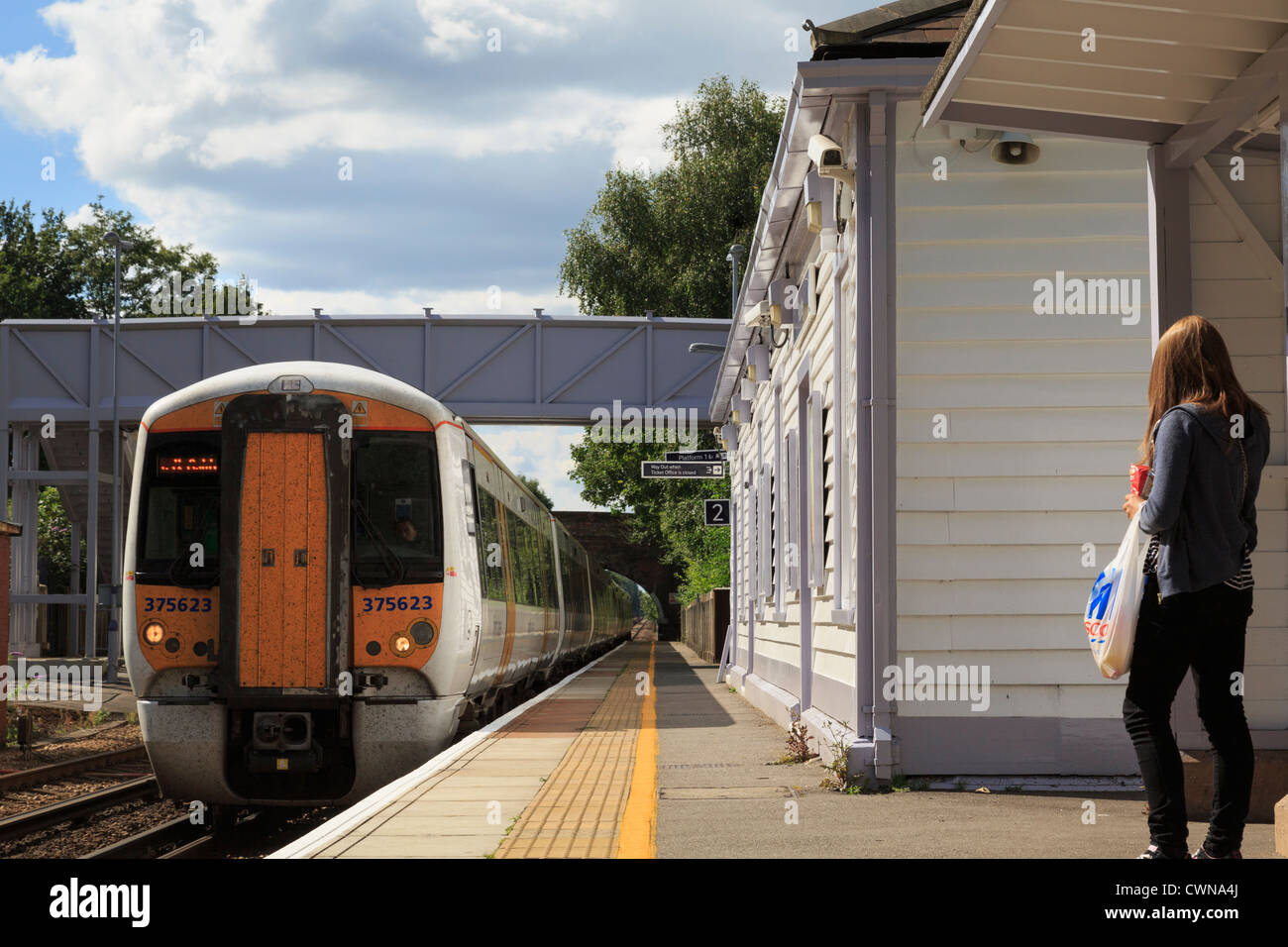 Passenger waiting for SouthEastern train approaching country railway station on London to Ashford line. Pluckley Kent England UK Stock Photo