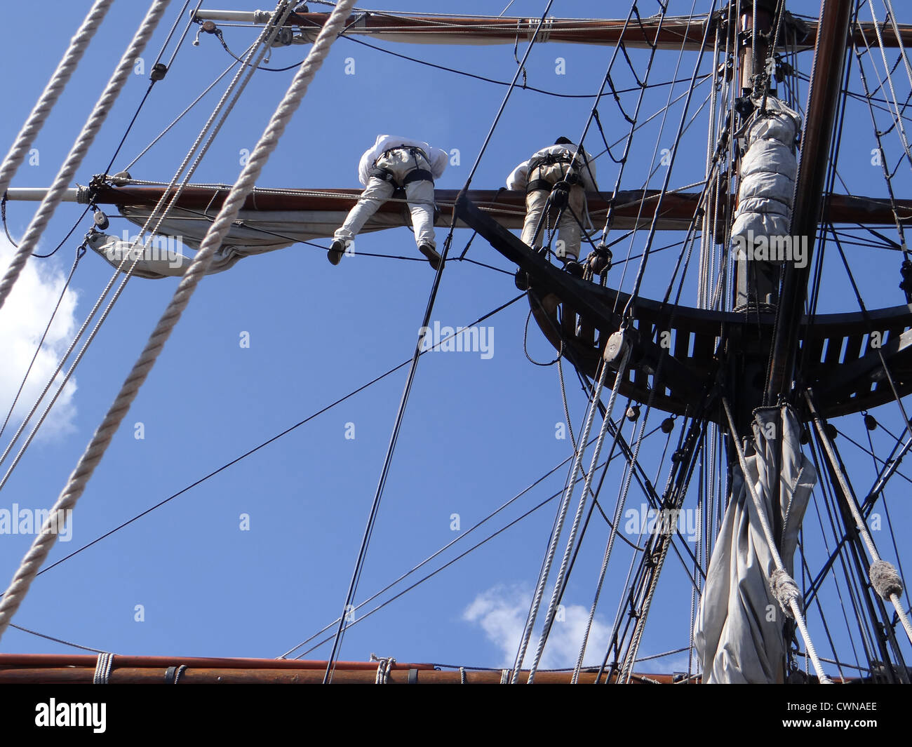 Crew unfurls a sail on a yardarm of a tallship near Kirkland, Washington  Stock Photo