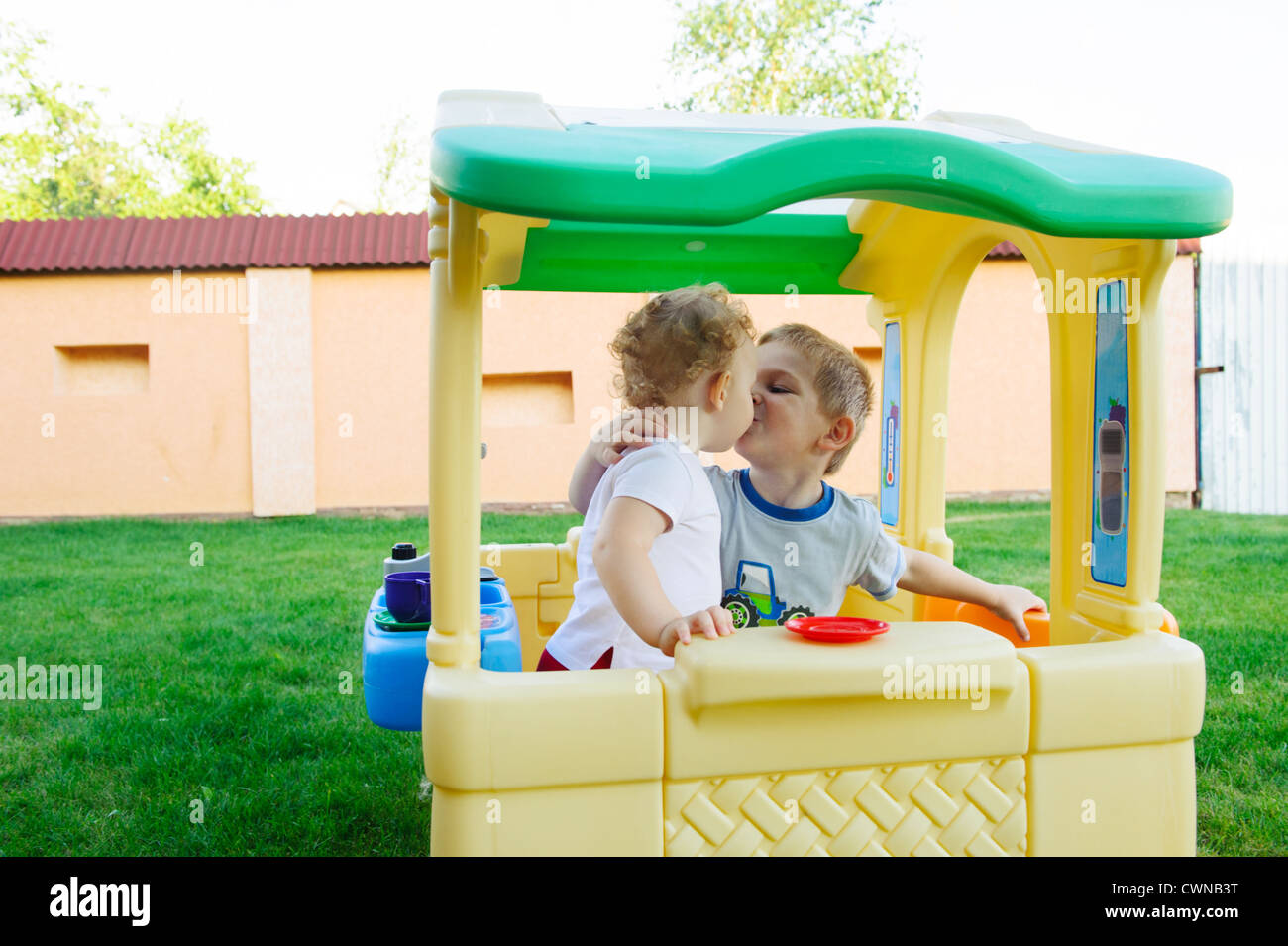Little boy and girl kissing in toy house outdoors Stock Photo Alamy