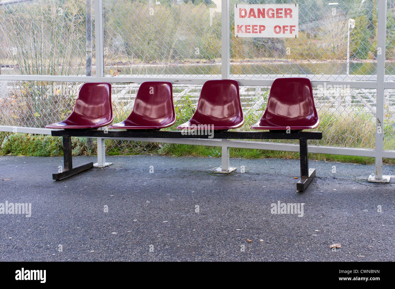 Seats in waiting area with a danger keep off sign. Stock Photo