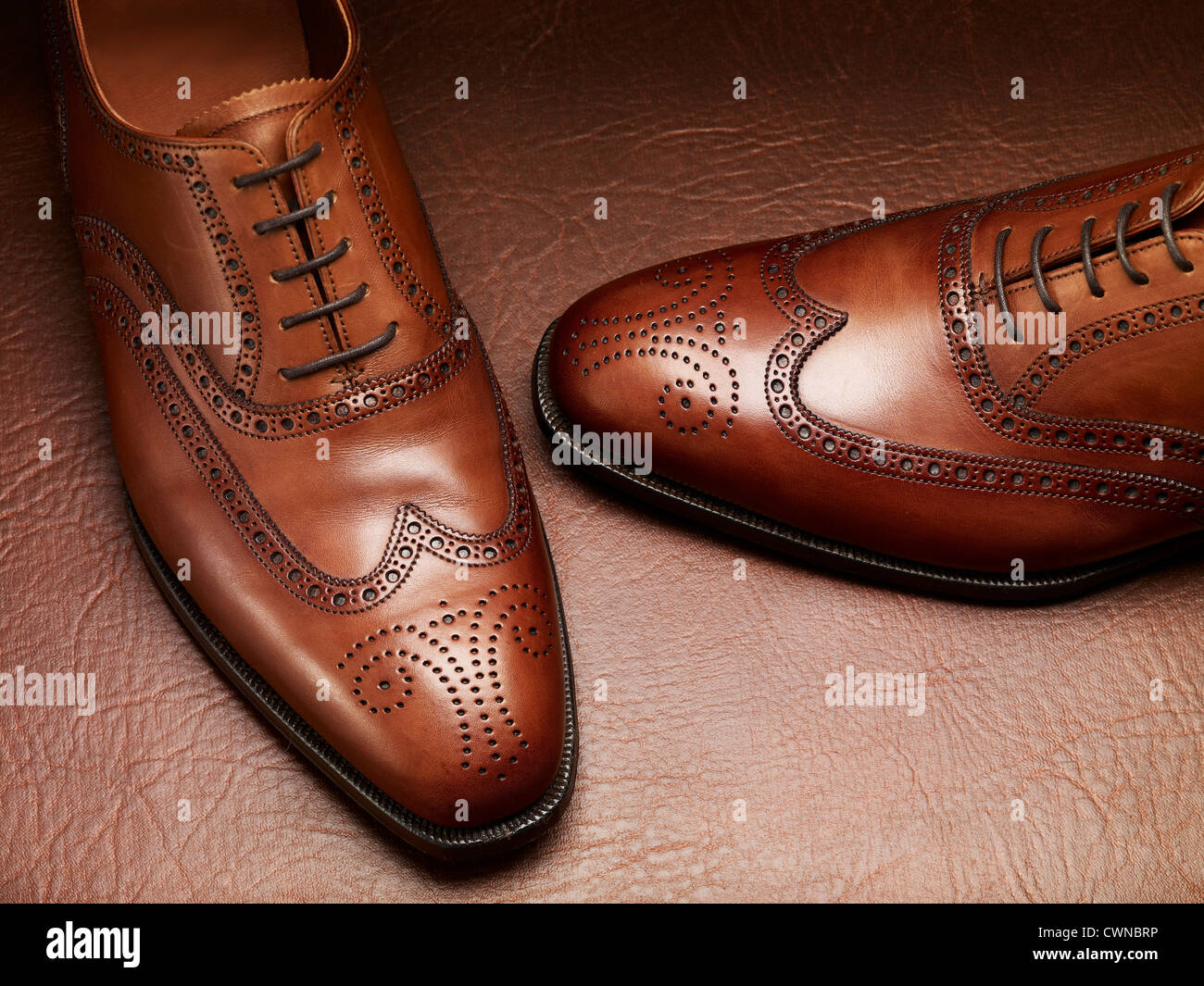 A pair of brown brogue shoes on a leather background Stock Photo