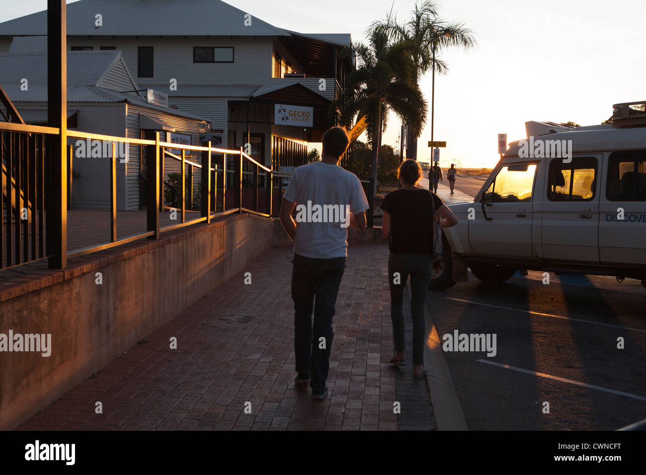 Two people walking in Broome Town, Western Australia, at sun set ...