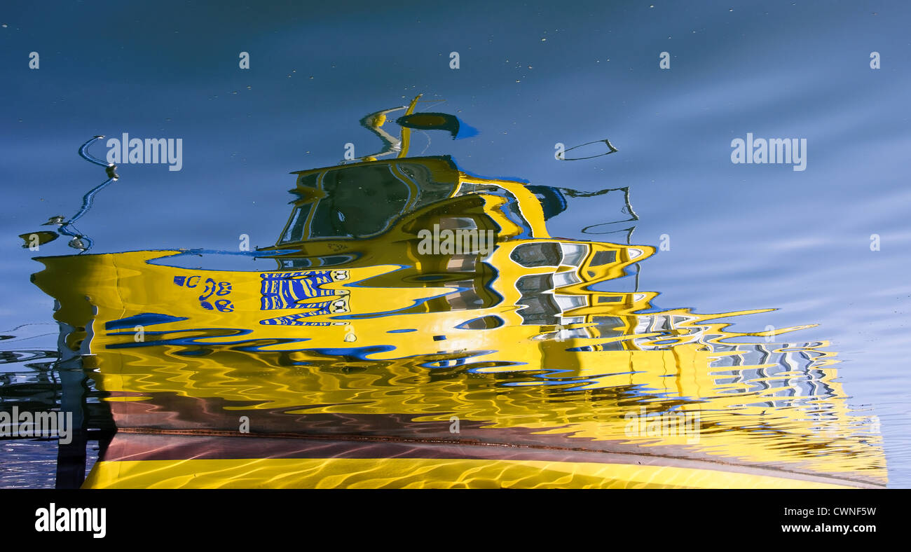 Yellow boat reflected on the water Stock Photo - Alamy