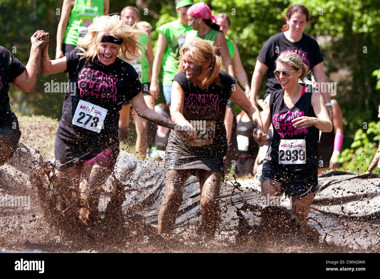 Women Run Through Mud In Obstacle Course Race Stock Photo