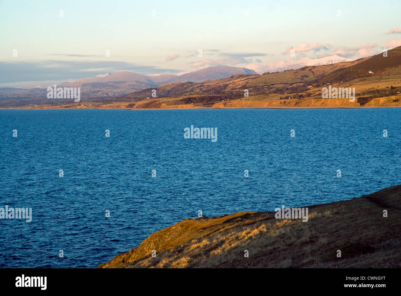 view looking across sea to snowdon range from trefor on the lleyn peninsula gwynedd north wales Stock Photo