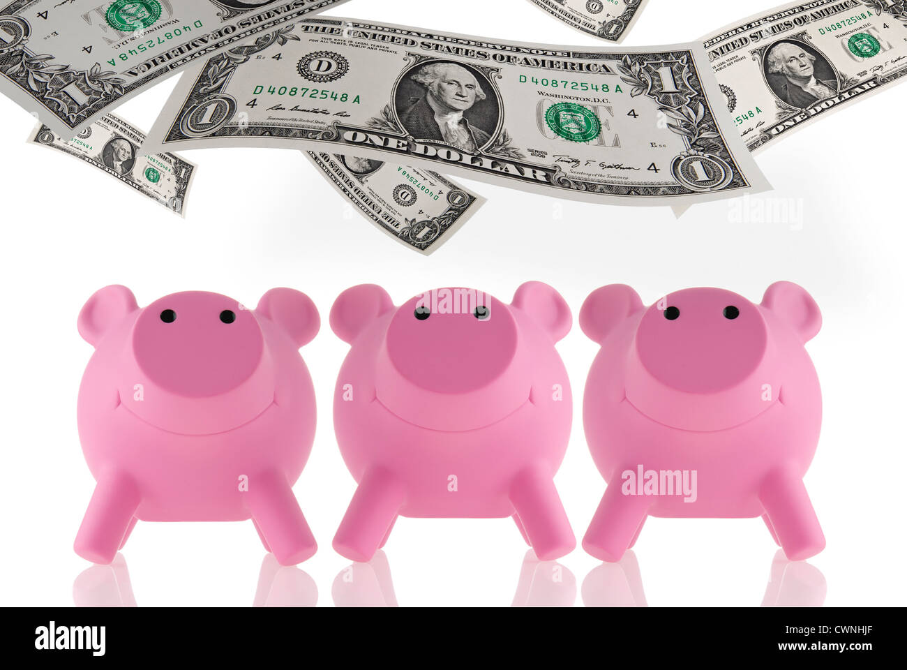 Pink piggy banks with floating banknotes, composing Stock Photo