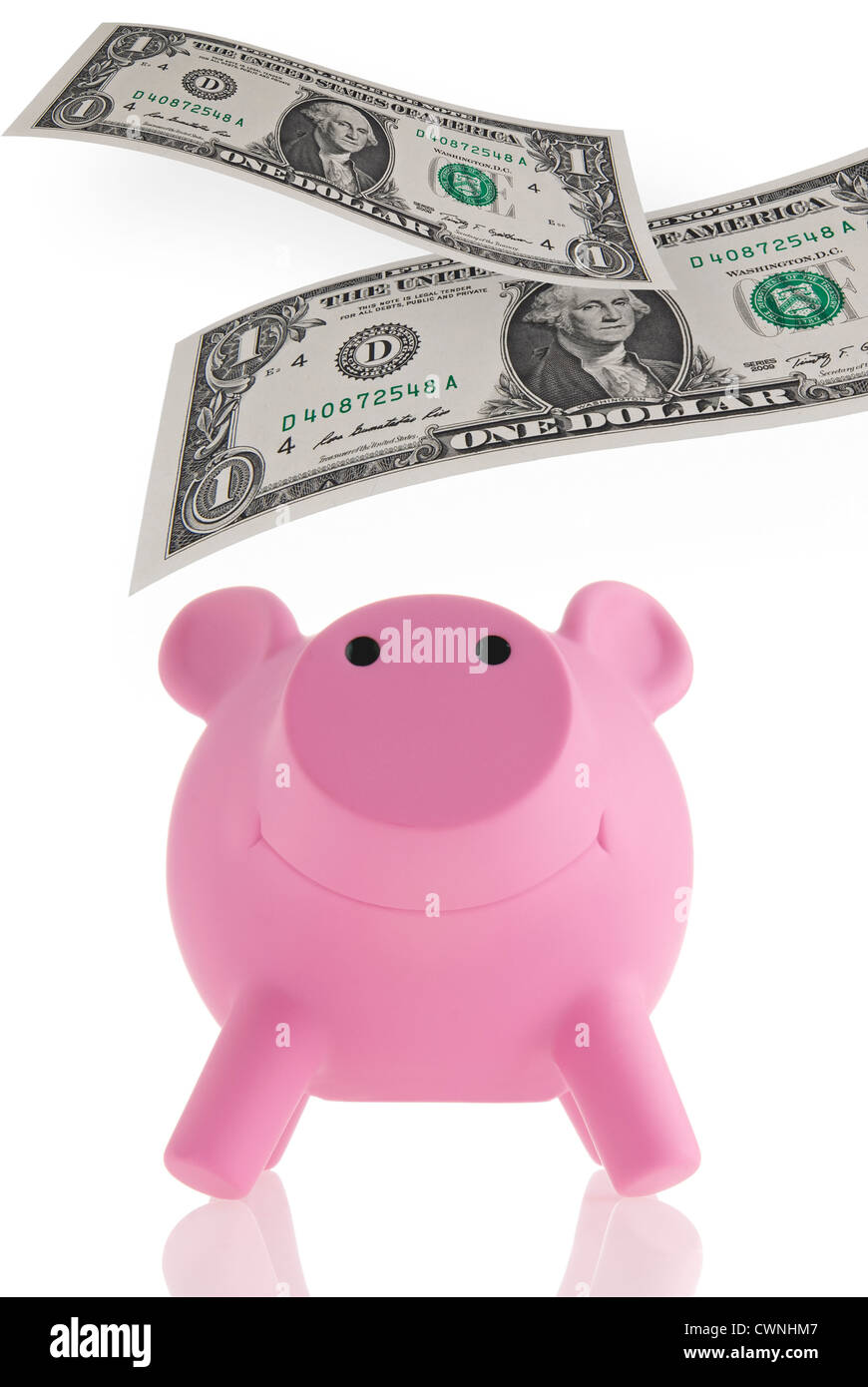 Pink piggy bank with floating banknotes, composing, isolated on 100% white background Stock Photo