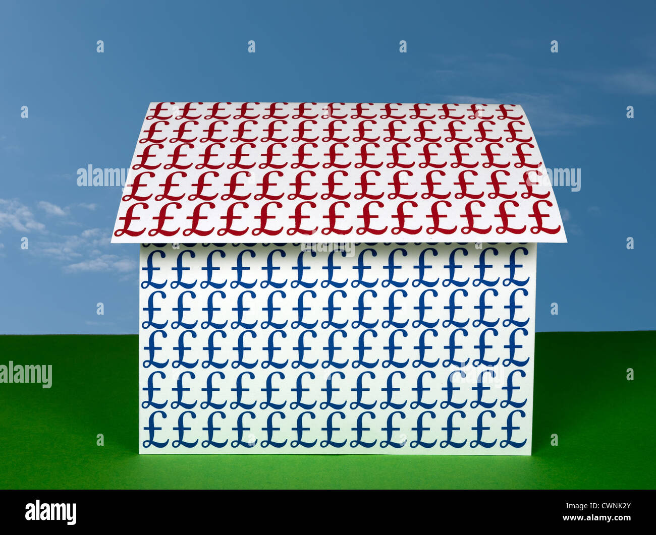 Paper house covered in UK pound signs on bright background. Stock Photo