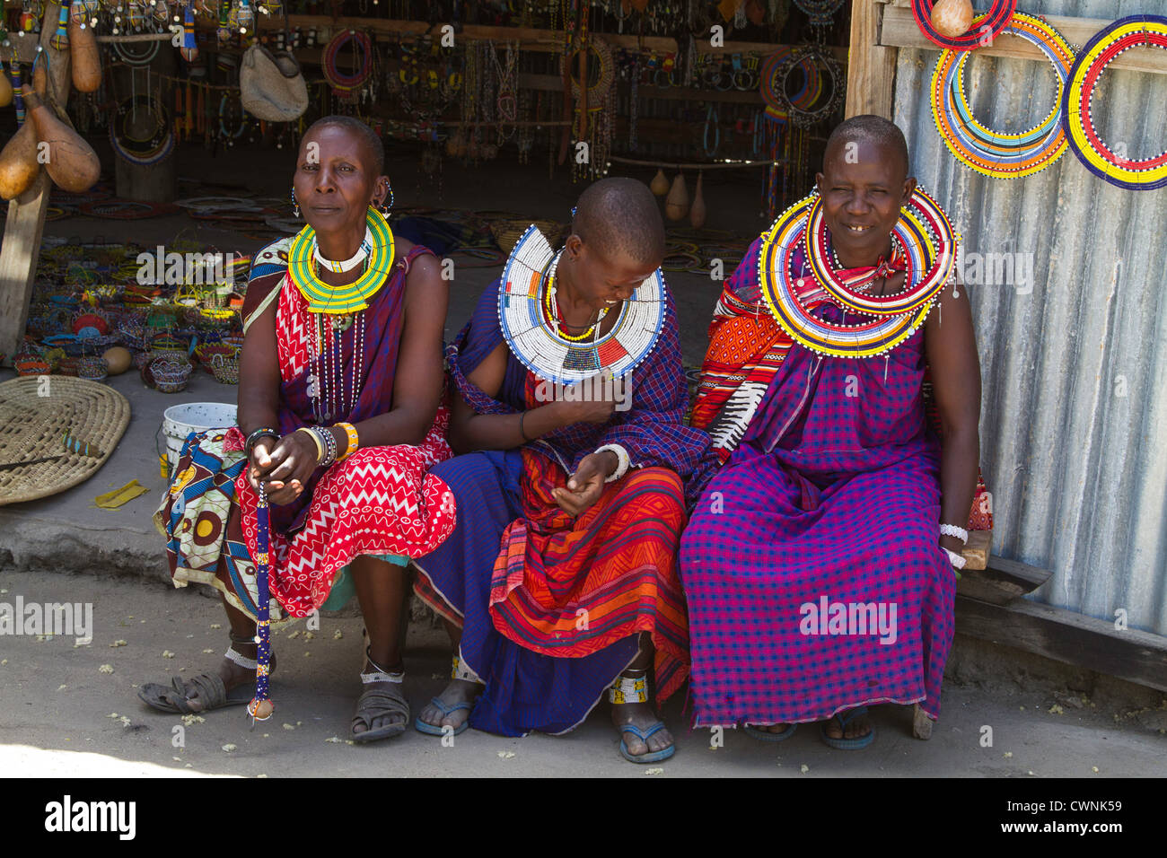 Three Maasai women, part of a womens cooperative, selling crafts in Tanzania, Africa. Stock Photo