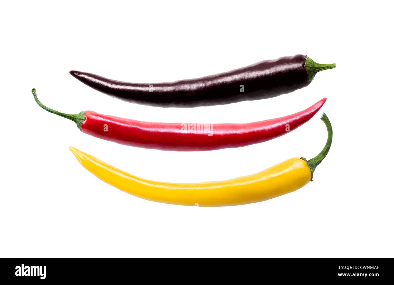 Three chili peppers in colours of german national flag, isolated on 100% white background Stock Photo