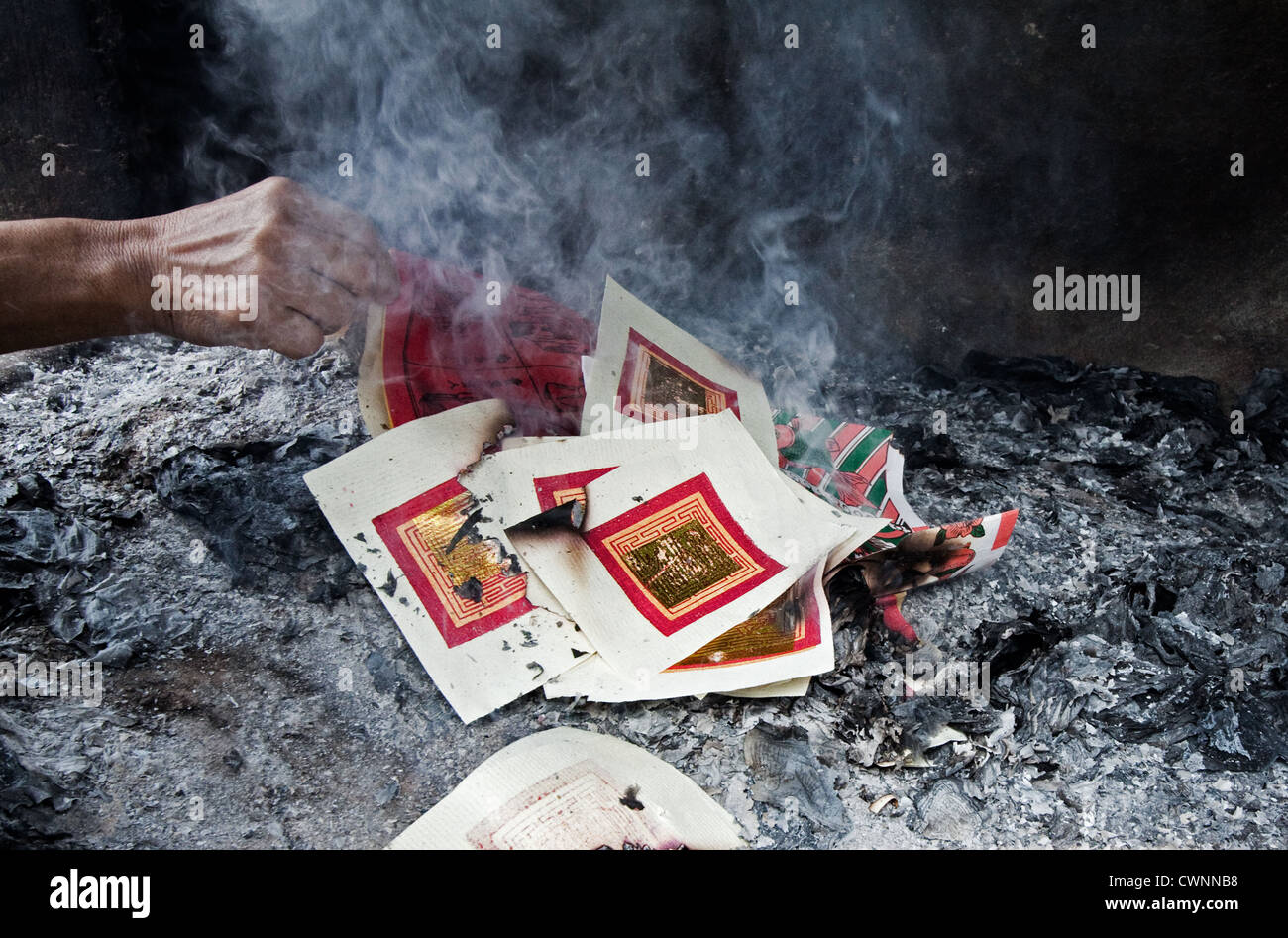 Buddhist Prayers on paper being burnt at a Buddhist Temple in Malaysia at a time of religious rituals on the Buddhist calendar Stock Photo