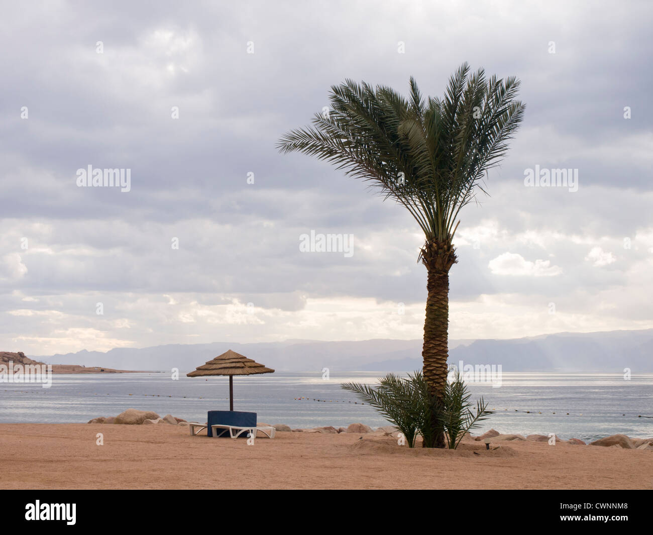 sea and beach at Tala Bay outside of Aqaba Jordan on the Red sea with Sinai in the background and threatening clouds Stock Photo